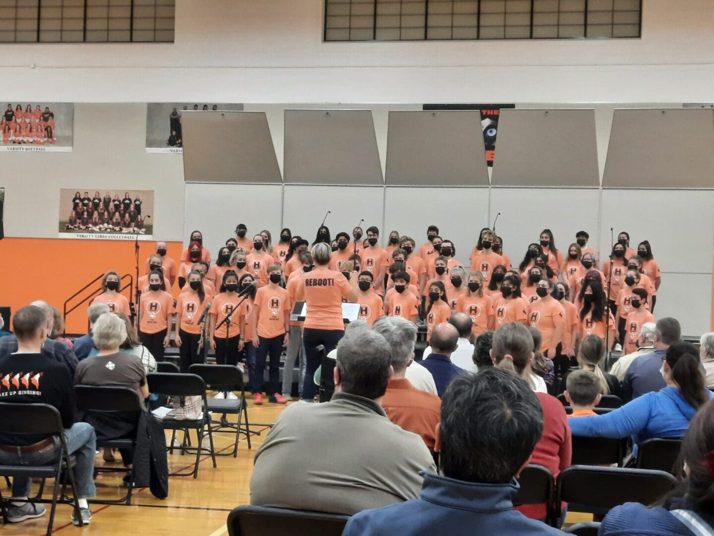 A group of people in orange shirts standing around.